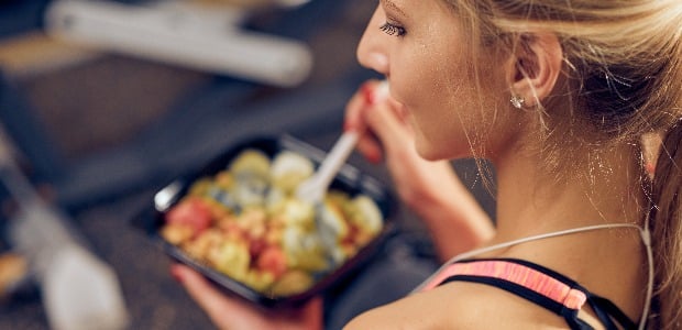 Top view of woman eating healthy food while sitting in a gym. Healthy lifestyle concept.